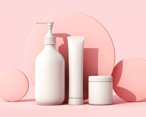 Glow Essentials Skincare Set — cleanser, treatment tube, and cream jar on a pink background